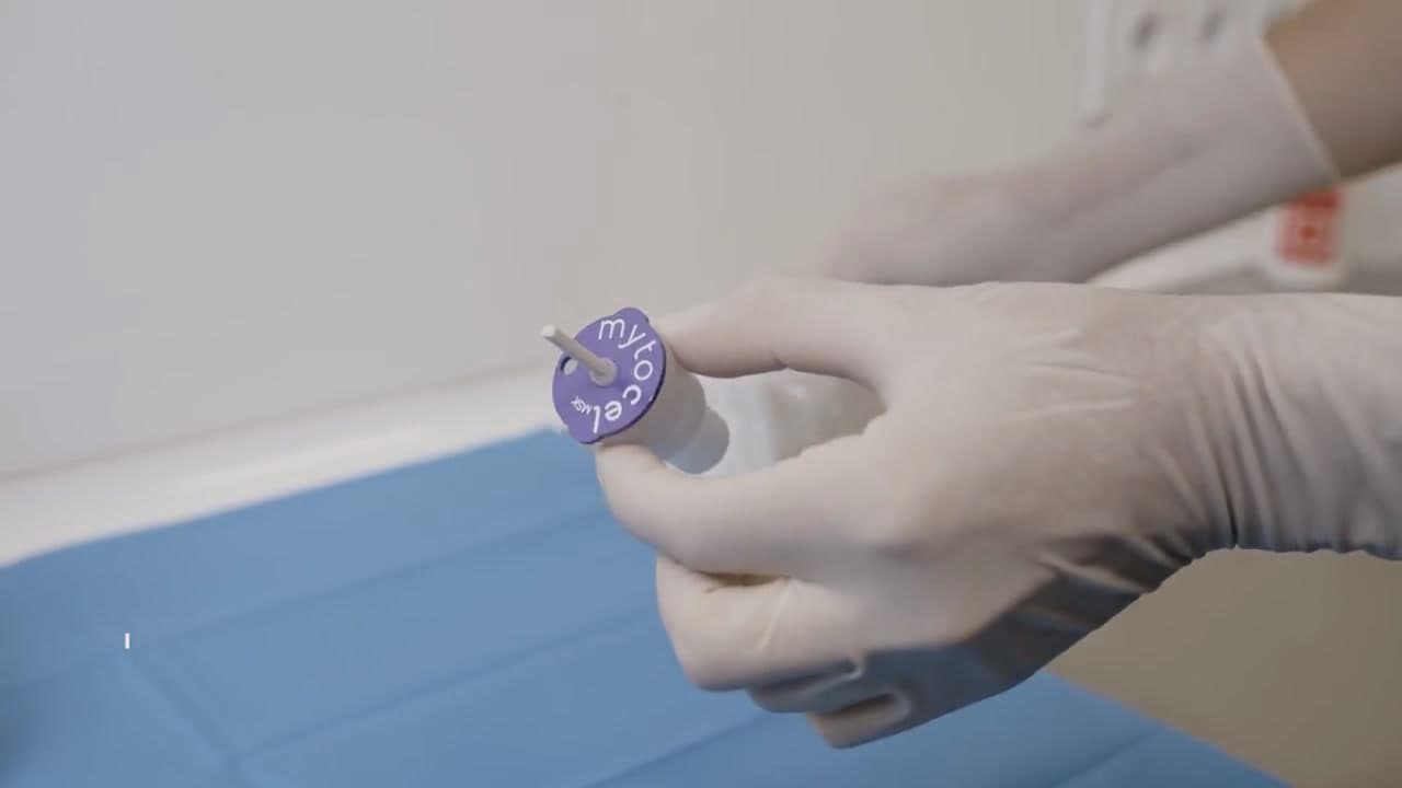 A gloved hand holding the sealed single-use cartridge in its pouch